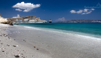 na začátku pláže Voudia je S&B zpracovatelský závod na perlit (v dáli na obzoru neobydlený ostrůvek Polyeghos)...