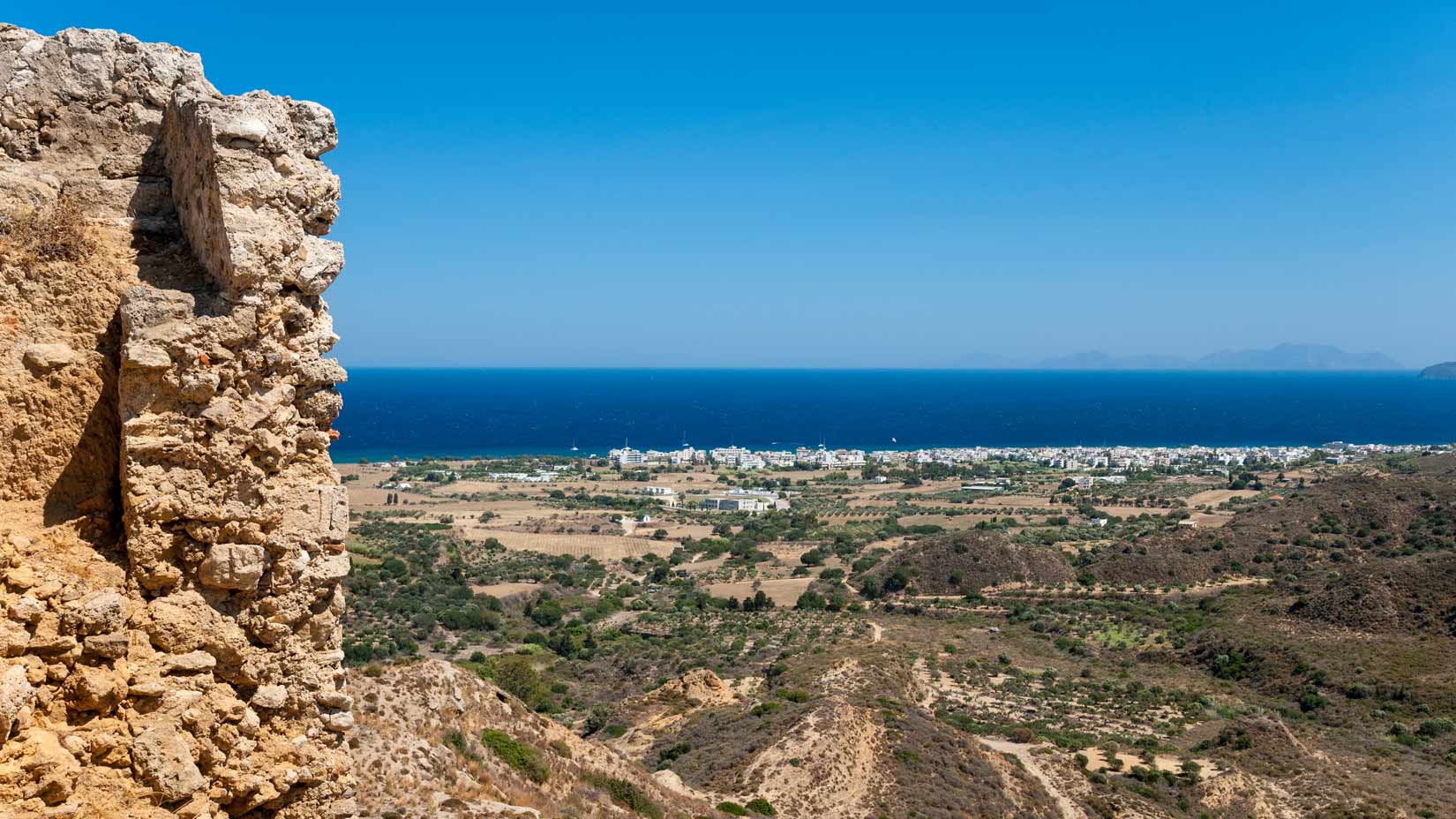 Výhled z opevnění hradu směrem k přístavu Kardámena. V dálce ostrov Nysiros